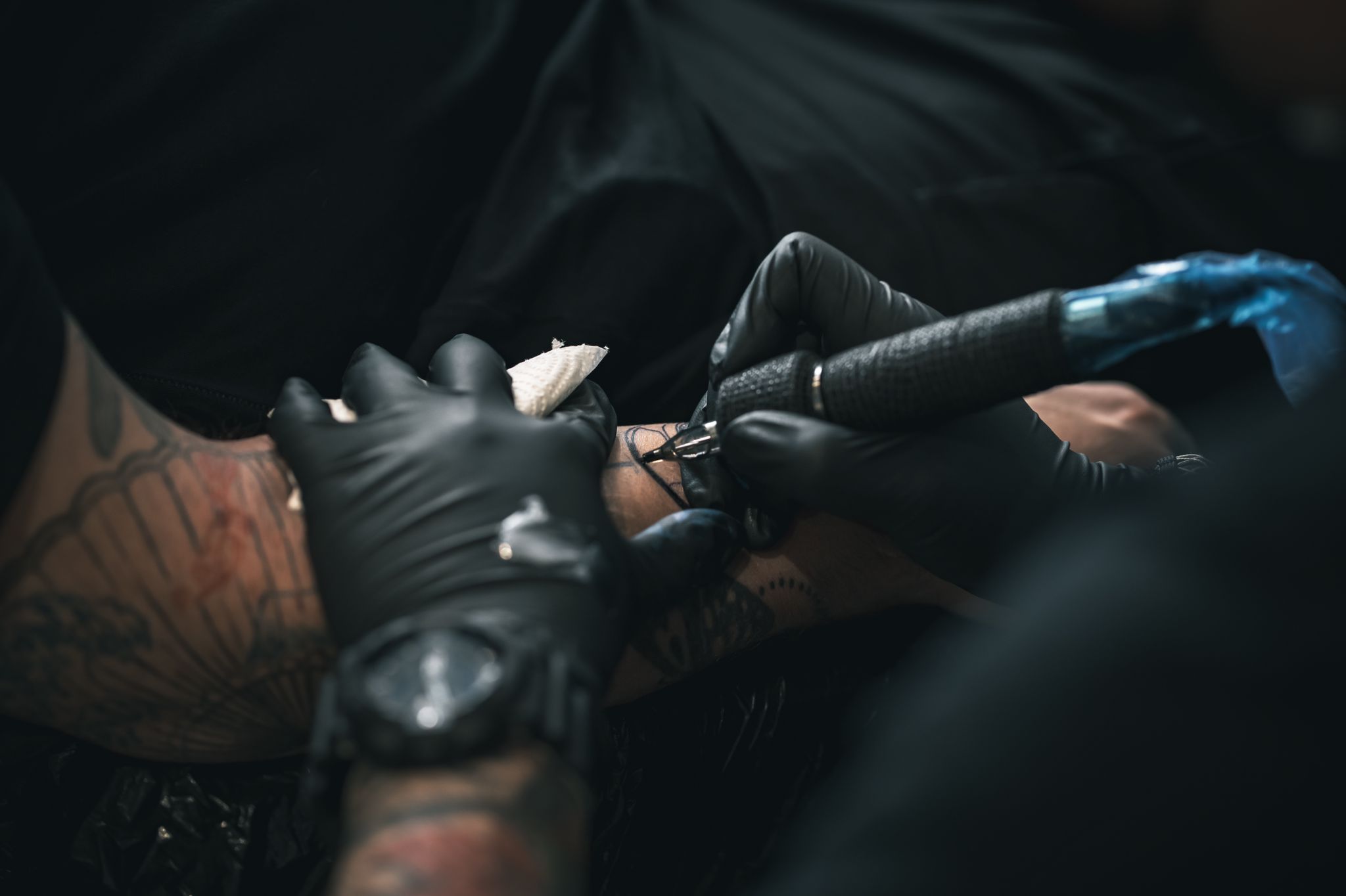 Tattoo artist applying a large stencil to a client's back.