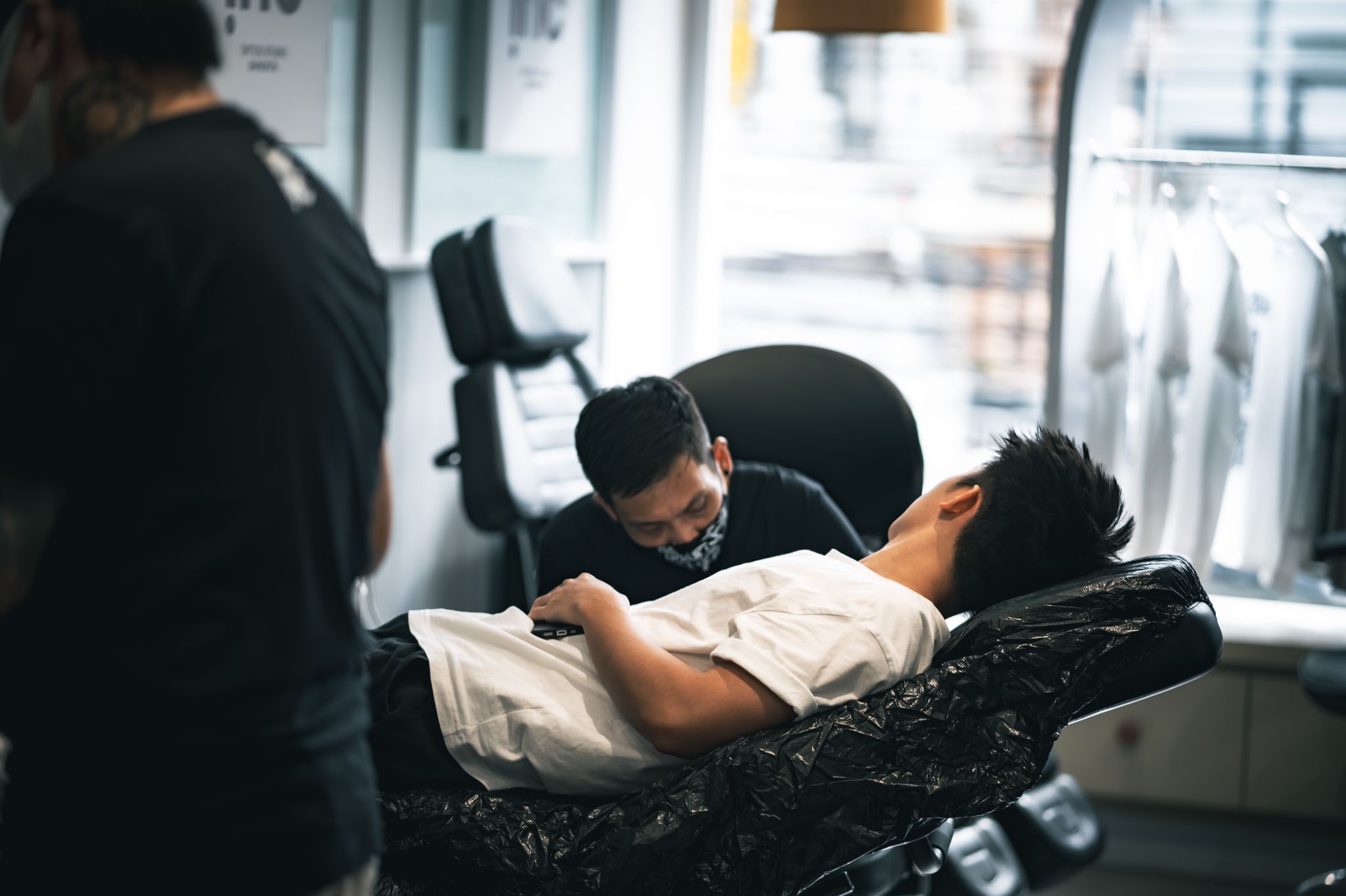 Tattoo shop staff member consulting with a client.