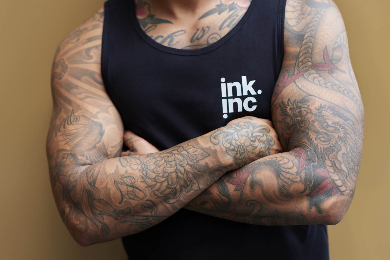muscular man with tattoos in black tank top with