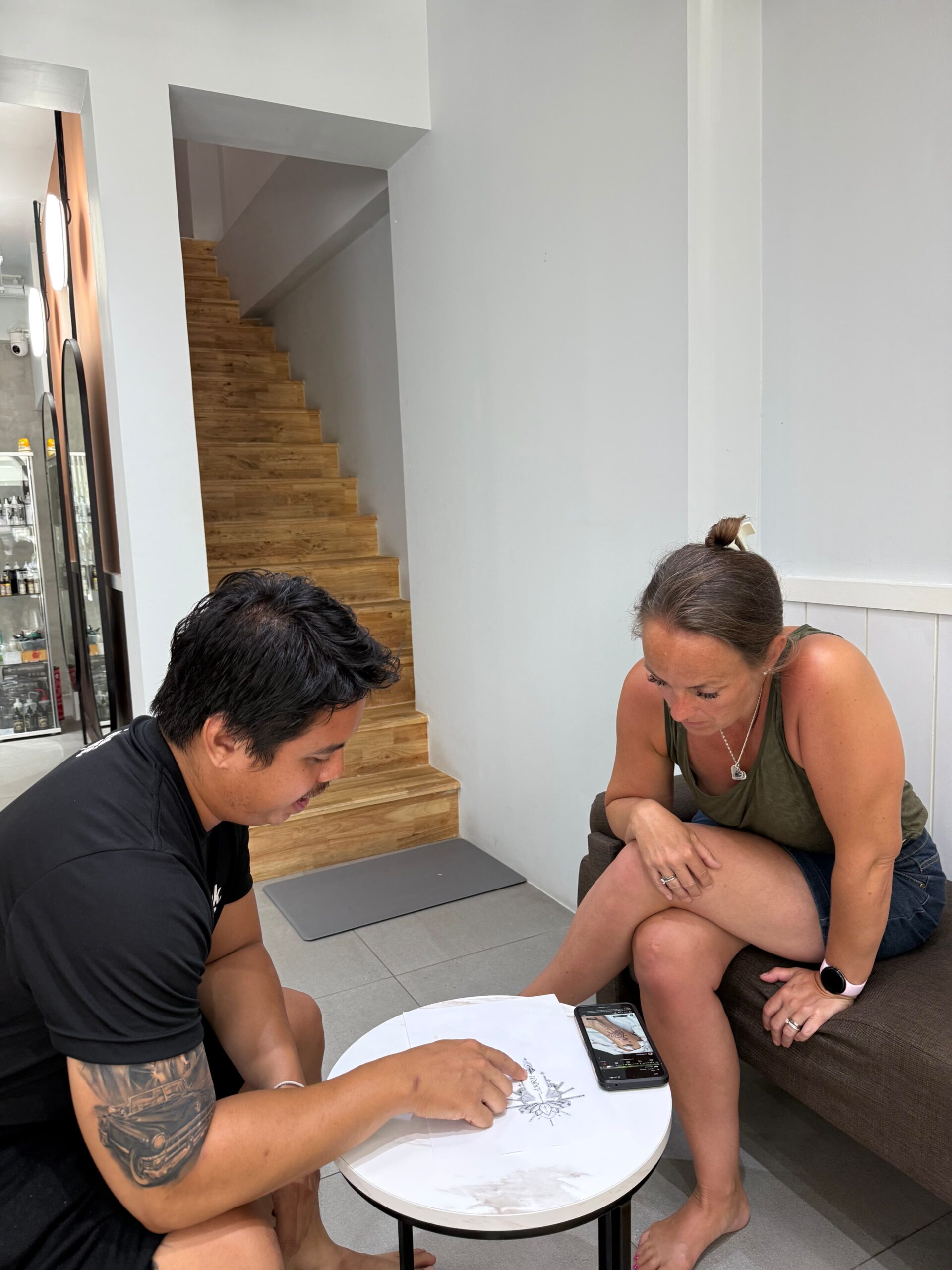 Tattoo shop staff member consulting with a client.