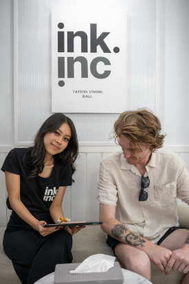 Tattoo shop staff member consulting with a client.