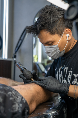 Tattoo shop staff member consulting with a client.