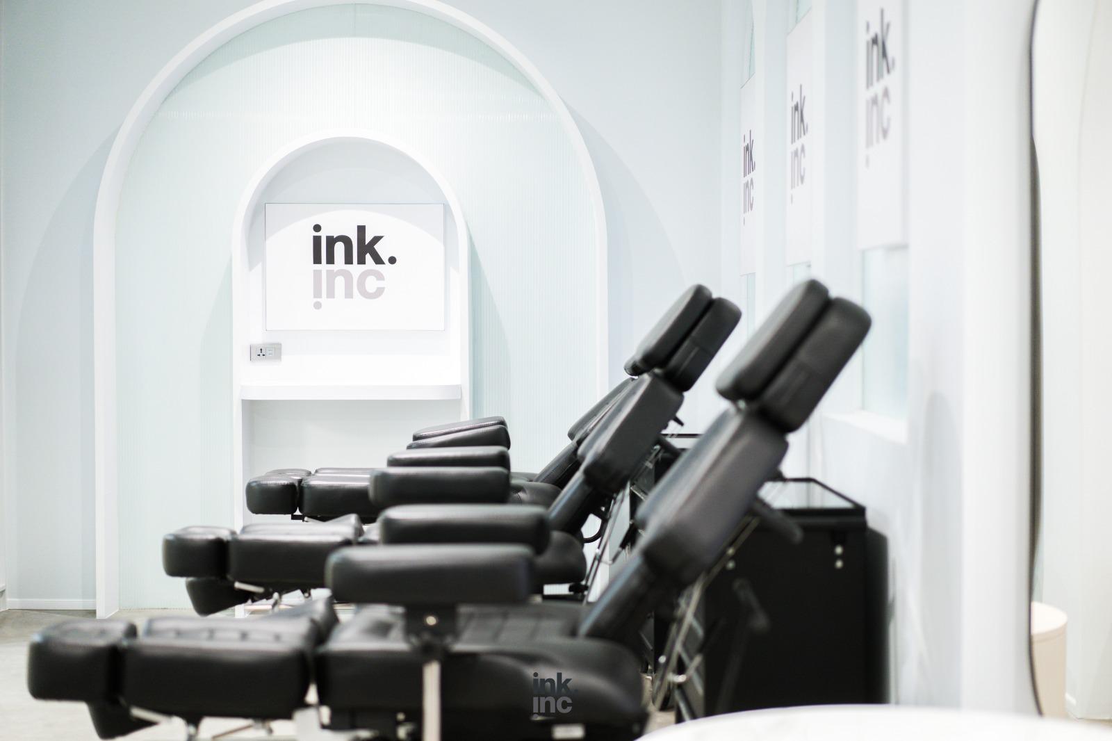 Clean and sterile tattoo station with a modern black chair.